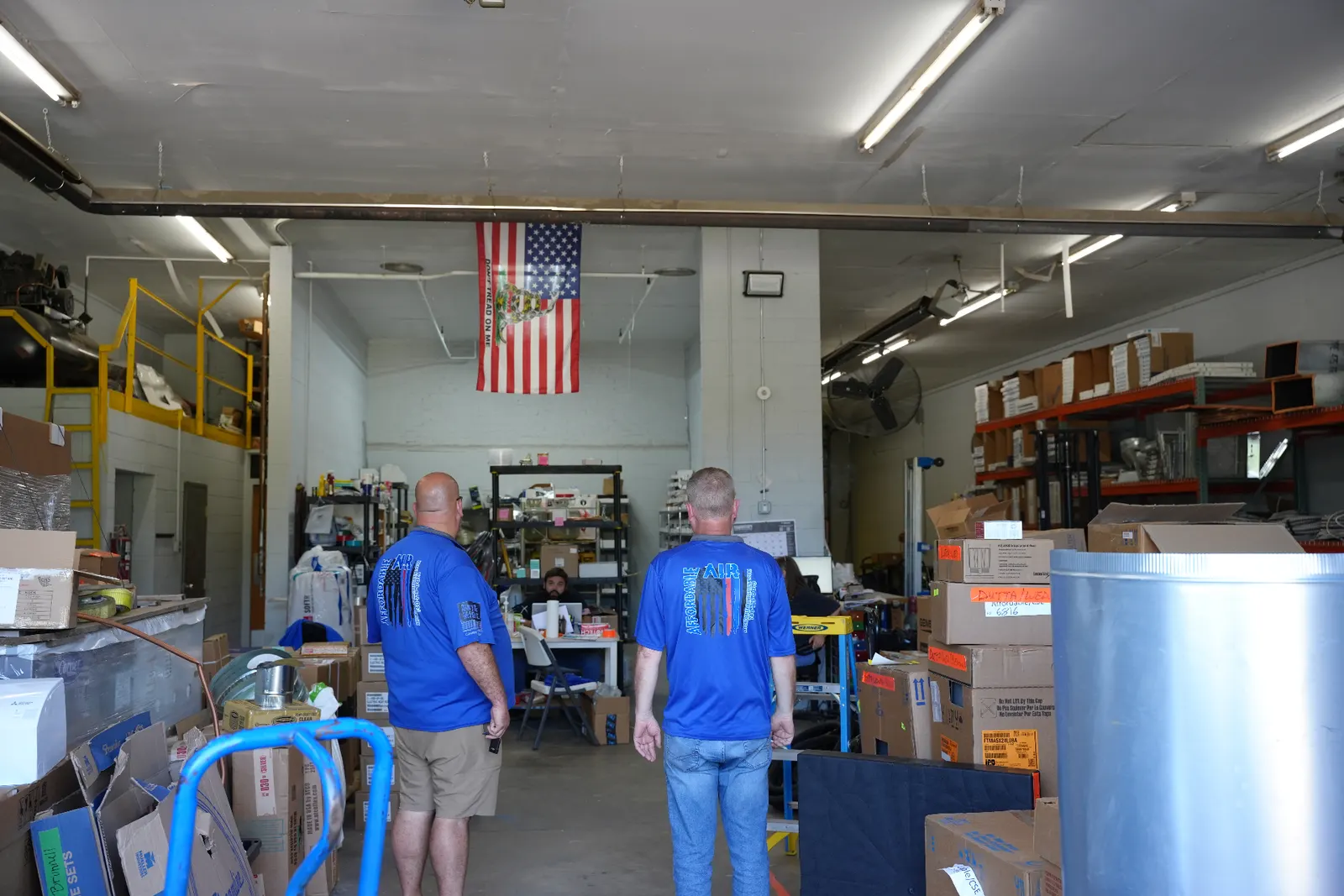 Two Affordable Air team members in company shirts walking through the Chillicothe shop and warehouse