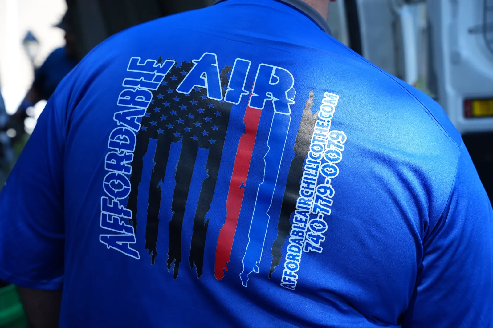 The back of an Affordable Air team shirt with the company logo, website and phone number