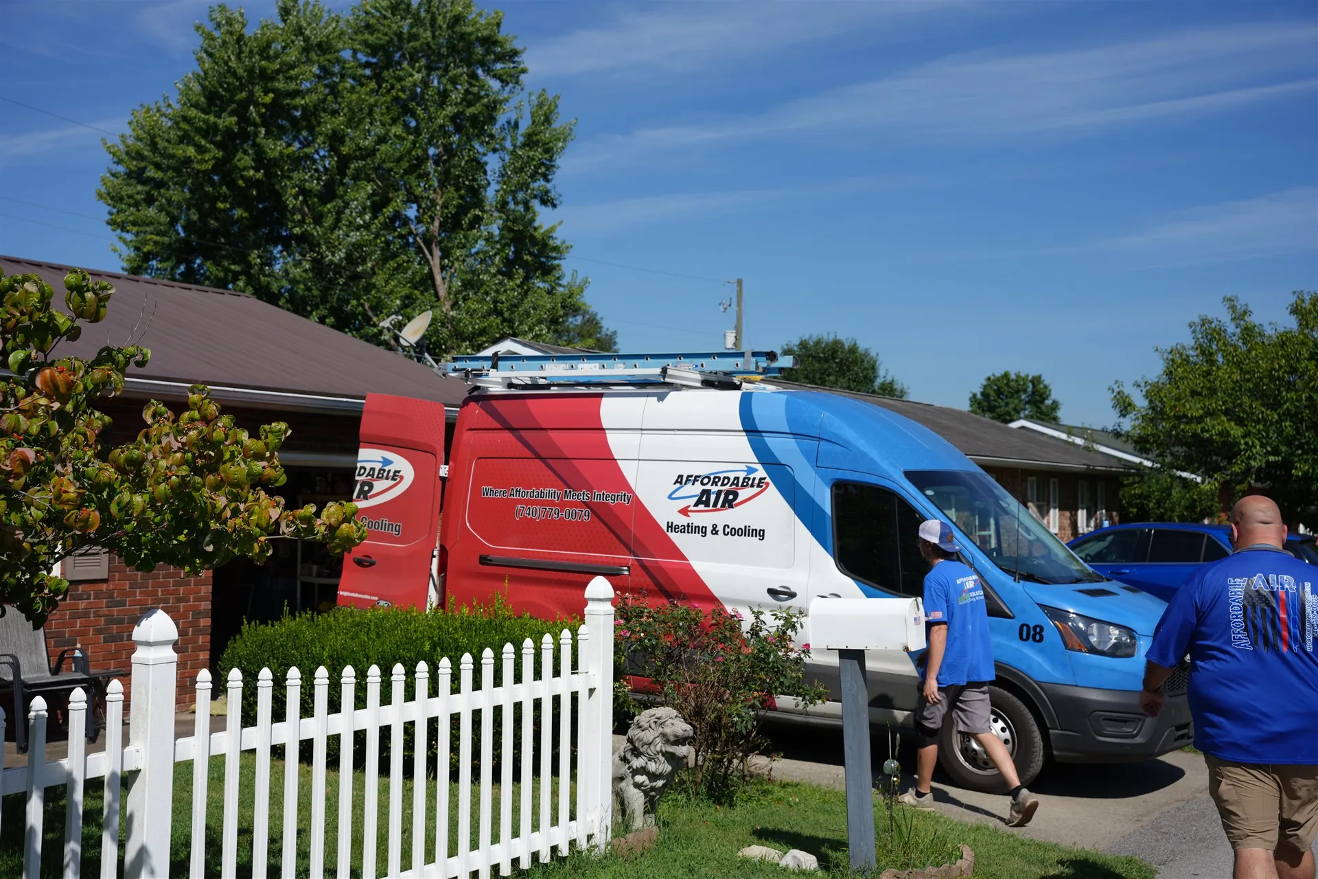 An Affordable Air technician walking toward a branded service van outside a home.